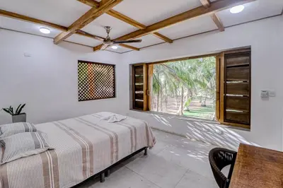 a bedroom with a bed and a large window at Mangue House in Playa San Miguel