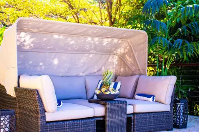 a couch sitting on a wicker chair on a patio at Luxury Home with Views and Infinity Pool Near Beach! in Puerto Viejo