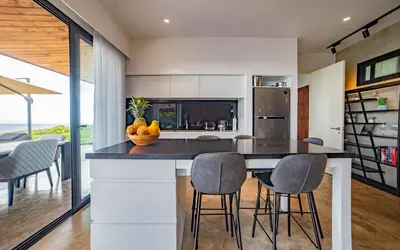 a kitchen with a island with chairs and a counter top at Casa Anna Santa Teresa in Santa Teresa Beach
