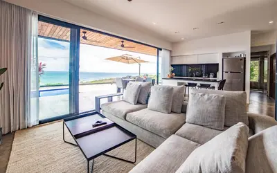 a living room with a couch and a view of the ocean at Casa Anna Santa Teresa in Santa Teresa Beach
