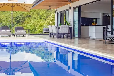 an outdoor swimming pool with a patio and a house at Casa Anna Santa Teresa in Santa Teresa Beach
