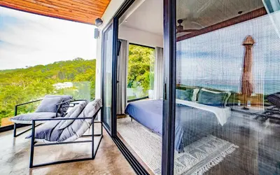 a bedroom with a bed and a balcony with a view at Casa Anna Santa Teresa in Santa Teresa Beach