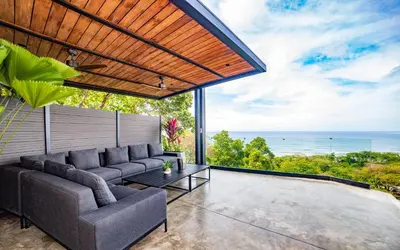 a living room with a couch and a view of the ocean at Casa Anna Santa Teresa in Santa Teresa Beach