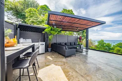 an outdoor kitchen and living room with a view of the ocean at Casa Anna Santa Teresa in Santa Teresa Beach