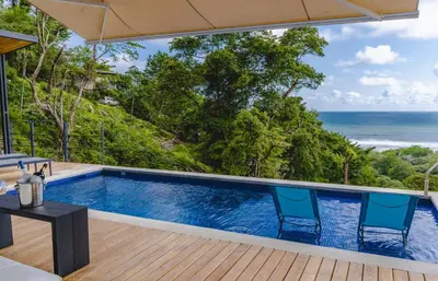 a pool with a view of the ocean at Le Suite in Santa Teresa Beach