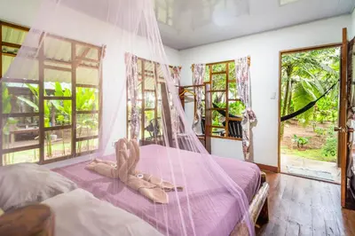 a bedroom with a canopy bed with a stuffed animal on it at Playa Ganadito Ecolodge in Drake