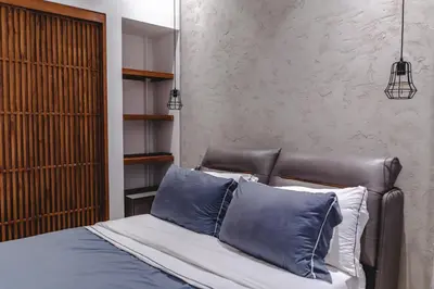 a bedroom with a leather bed with blue pillows at Casa Nina Santa Teresa in Santa Teresa Beach