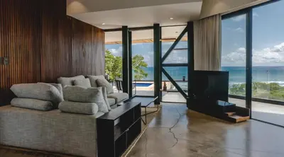 a living room with a couch and a television at Casa Nina Santa Teresa in Santa Teresa Beach