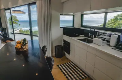 a kitchen with a table and a view of the ocean at Casa Nina Santa Teresa in Santa Teresa Beach