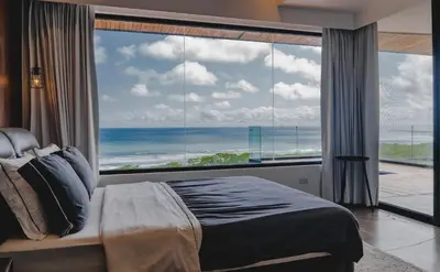 a bedroom with a large window with a view of the ocean at Casa Nina Santa Teresa in Santa Teresa Beach