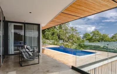 a house with a swimming pool and glass walls at Casa Nina Santa Teresa in Santa Teresa Beach