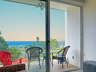 a patio with chairs and a table with a view of the ocean at SUNSET OCEAN VIEW CONDO in Jacó