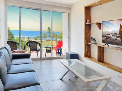 a living room with a couch and a glass table at SUNSET OCEAN VIEW CONDO in Jacó