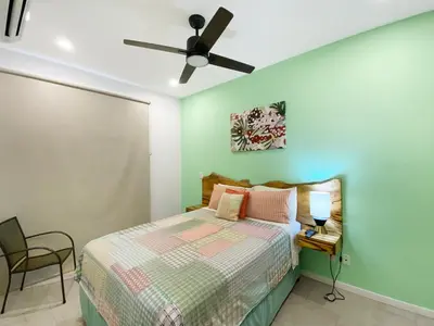 a bedroom with a bed and a ceiling fan at SUNSET OCEAN VIEW CONDO in Jacó