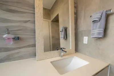 a bathroom with a sink and a mirror at SUNSET OCEAN VIEW CONDO in Jacó