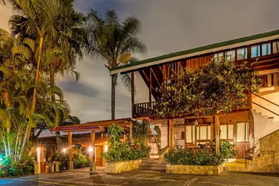 a house with palm trees in front of it at Costa Verde Inn in San José