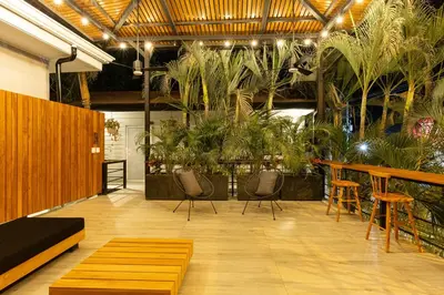 a room with chairs and tables and potted plants at Ventura Santa Teresa in Santa Teresa Beach