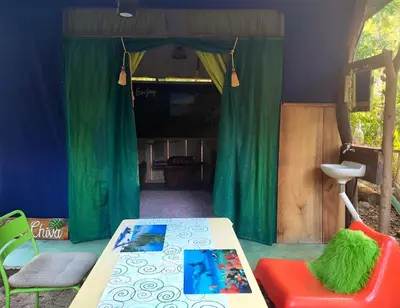 a room with a table and a green curtain at Jungle Tent 3x3, Latino Glamping & Tours, Paquera in Paquera