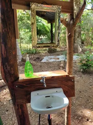 a bathroom with a sink and a mirror at Jungle Tent 3x3, Latino Glamping & Tours, Paquera in Paquera