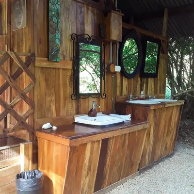 a wooden bathroom with two sinks and two mirrors at Jungle Tent 3x3, Latino Glamping & Tours, Paquera in Paquera