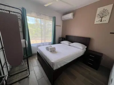 a small bedroom with a bed with a window at Encantadora Casa Amapolas in Cóbano
