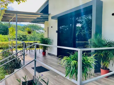a house with a balcony with potted plants at Encantadora Casa Amapolas in Cóbano
