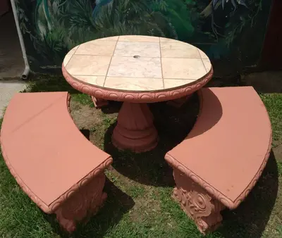 a table with two benches around it in the grass at Hotel La Puesta Del Sol B&B in Monteverde Costa Rica