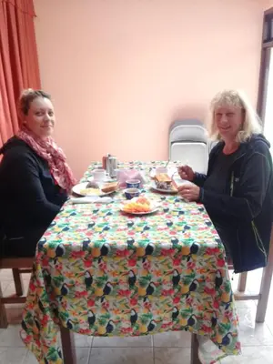 two women sitting at a table with food on it at Hotel La Puesta Del Sol B&B in Monteverde Costa Rica