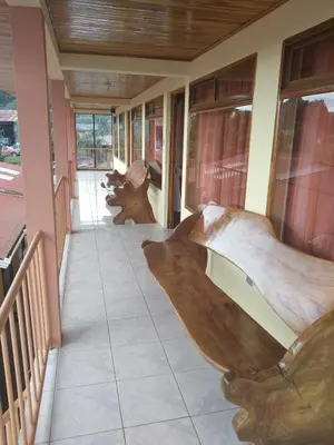 a room with wooden furniture on a balcony at Hotel La Puesta Del Sol B&B in Monteverde Costa Rica