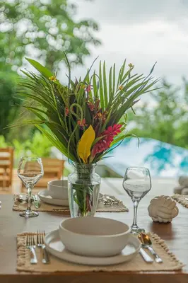 a table with plates and a vase with flowers on it at Casa Mirame in Carmen