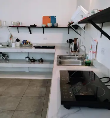 a kitchen with a sink and a stove at Casajungla Hostel in Jacó