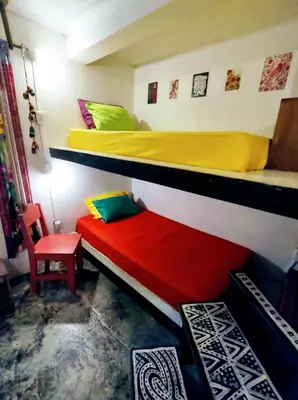 a bedroom with two bunk beds and a chair at Casajungla Hostel in Jacó
