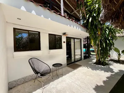 a chair sitting in front of a house at Hotel El Manglar y Cantarana in Playa Grande