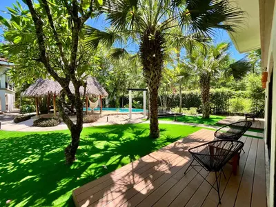 a deck with two benches and a yard with palm trees at Hotel El Manglar y Cantarana in Playa Grande