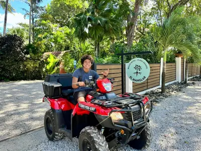 a man sitting on a four wheeler vehicle at Hotel El Manglar y Cantarana in Playa Grande