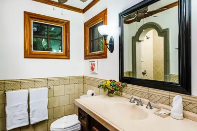 a bathroom with a sink and a toilet and a mirror at La Esquina (3 minutes from Beach, perfect for a family getaway) in Tamarindo