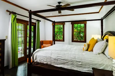 a bedroom with a large bed with yellow pillows at La Esquina (3 minutes from Beach, perfect for a family getaway) in Tamarindo