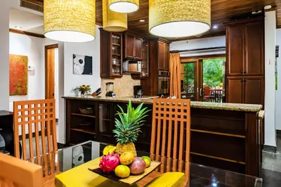 a kitchen with a table with a bowl of fruit on it at La Esquina (3 minutes from Beach, perfect for a family getaway) in Tamarindo