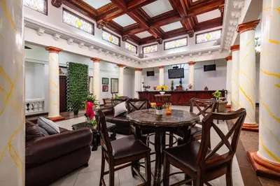 a living room with a table and chairs at Hotel Majestad in San José