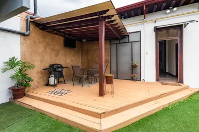 a wooden deck with a grill on a house at Hotel Majestad in San José