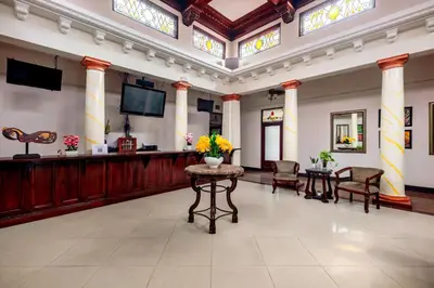 a lobby with a waiting area with flowers on a table at Hotel Majestad in San José