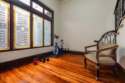 a room with a chair and stained glass windows at Hotel Majestad in San José