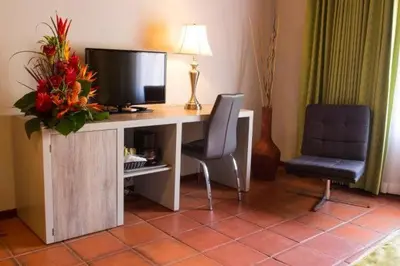 a room with a desk with a television and two chairs at Villa del Sueño in Playa Hermosa