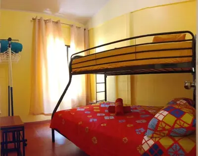 a bedroom with a bunk bed with a red bedspread at Casita El Sonido de las Aves in Uvita