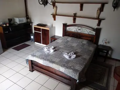 a bedroom with a bed with two white flowers on it at Confortable y privado estudio en zona exclusiva . in San José