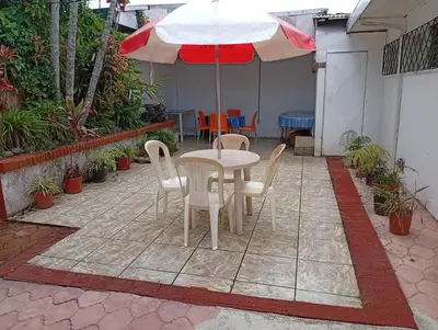 a patio with a table and chairs and an umbrella at Confortable y privado estudio en zona exclusiva . in San José