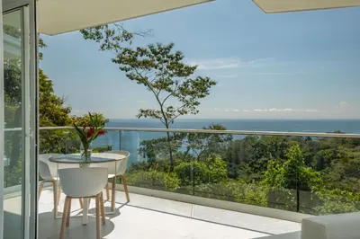 a balcony with a table and chairs and a view of the ocean at Adeluna Luxury Villas in Montezuma