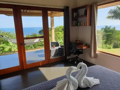 two swans in a bedroom with a view of the ocean at Palmetto Lodge in Playa San Miguel