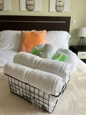 a basket of towels sitting on top of a bed at CR MARIPOSA RENTALS Cozy Retreat with Pool,Tennis,Gym,Free WiFi in Santa Ana