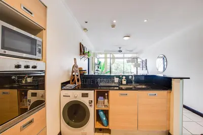 a kitchen with a washing machine and a sink at CR MARIPOSA RENTALS Cozy Retreat with Pool,Tennis,Gym,Free WiFi in Santa Ana